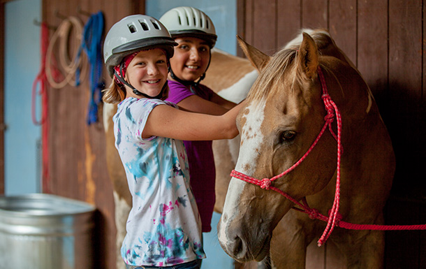 two girls petting a horse