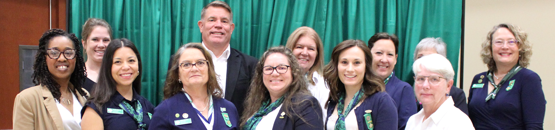  girl scout staff or volunteer wearing adult vest in woods smiling 